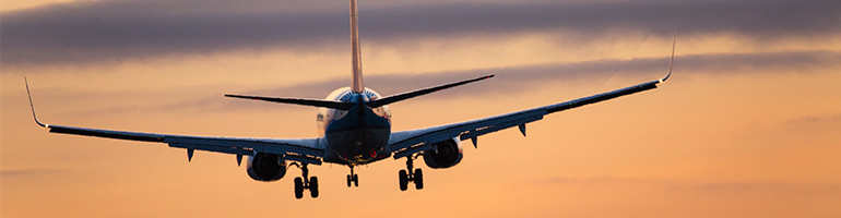 Flugzeug fliegt Sonnenuntergang entgegen - Beitragsbild Fluggesellschaften Aktien kaufen